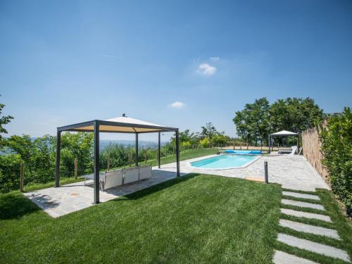 een achtertuin met een zwembad en een parasol bij Holiday Home Cascina-2 by Interhome in Costigliole dʼAsti