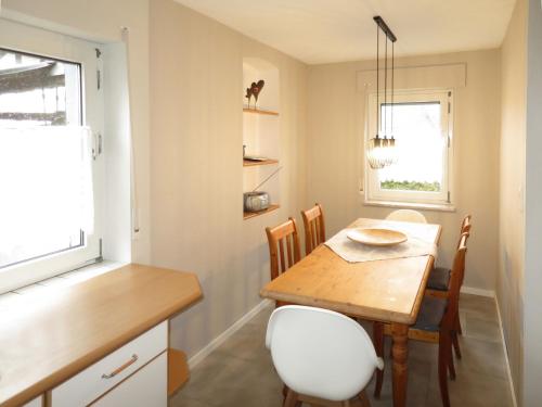 een keuken en eetkamer met een houten tafel en stoelen bij Holiday Home Haus Irmgard by Interhome in Haserich