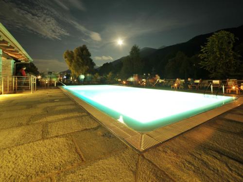 a swimming pool lit up at night at Apartment Casa del Ponte - SMY612 by Interhome in Sampeyre