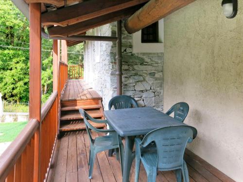 a wooden deck with a table and chairs on a porch at Apartment Casa del Ponte - SMY612 by Interhome in Sampeyre