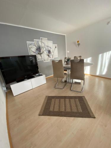 een woonkamer met een televisie en een tafel en stoelen bij Ferienwohnungen Löhr in Koblenz