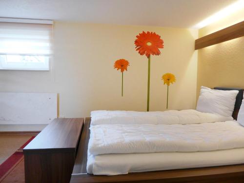sypialnia z 2 łóżkami i kwiatami na ścianie w obiekcie Holiday Home Edelmann by Interhome w mieście Schnett
