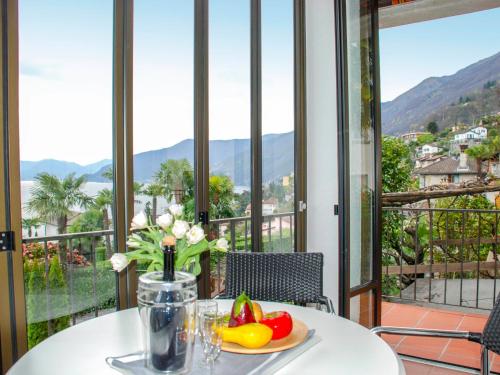 una mesa con una bandeja de fruta y flores en el balcón en Holiday Home Stellina del Sole by Interhome, en Brissago