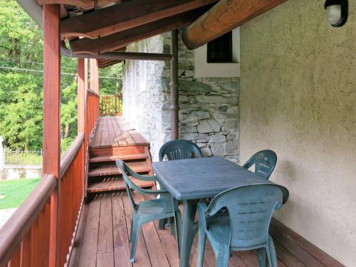 a table and chairs on the porch of a house at Apartment Casa del Ponte - SMY622 by Interhome in Sampeyre