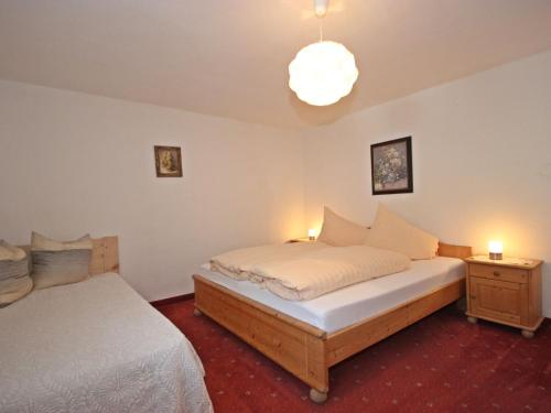 1 dormitorio con 2 camas y lámpara de araña en Apartment Schimpfössl Katharina-3 by Interhome, en Sankt Anton am Arlberg