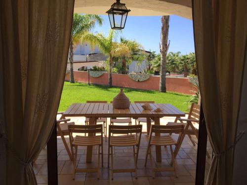 a wooden table and chairs on a patio at Villa Maris Capo Vaticano in Capo Vaticano
