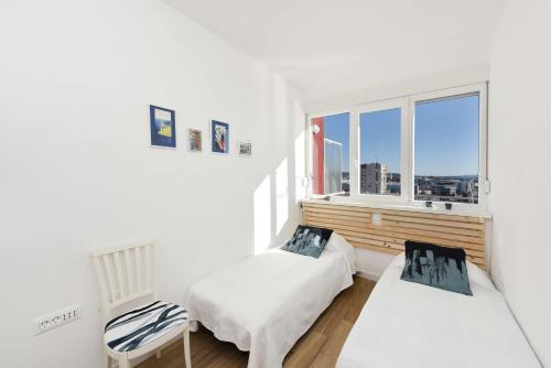 biały pokój z 2 łóżkami i oknem w obiekcie Penthouse Dolcevita w mieście Zadar