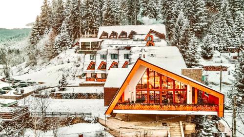 un complexe dans les montagnes dans la neige dans l'établissement Popasul Domnesc- Resort& Spa- Voronet Vue, à Voroneț