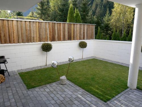 a small backyard with a fence and grass at Apartment Matt by Interhome in See