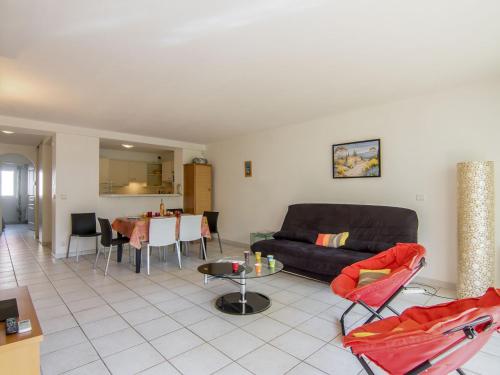 a living room with a couch and a table at Apartment Le Magellan-1 by Interhome in Saint-Raphaël