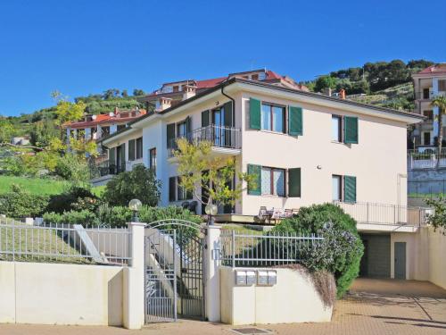 a large white house with a fence at Apartment Cielsereno - SLR246 by Interhome in Costarainera