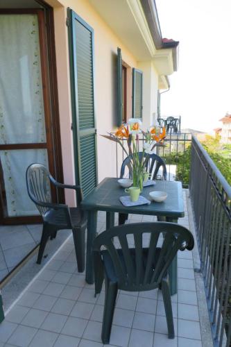 a table and chairs on a balcony with flowers on it at Apartment Cielsereno - SLR246 by Interhome in Costarainera