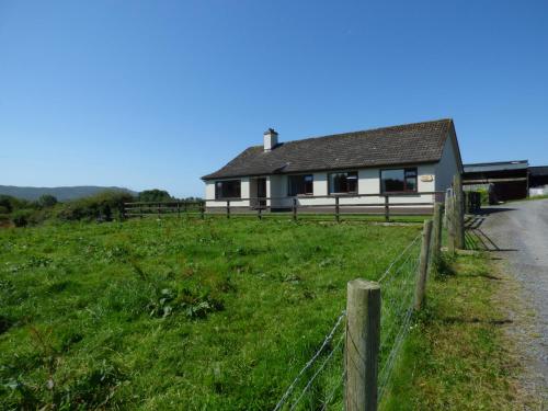 una casa al lado de un campo con una valla en Nephin View, en Levally