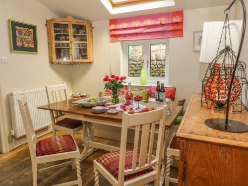 a dining room with a wooden table and chairs at 1 Bridge End & Garden in Grassington