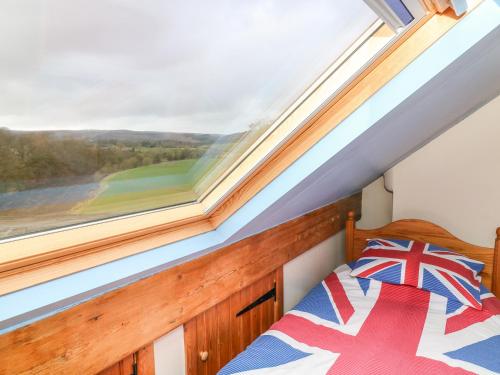 a bedroom with a bed and a large window at 1 Bridge End & Garden in Grassington