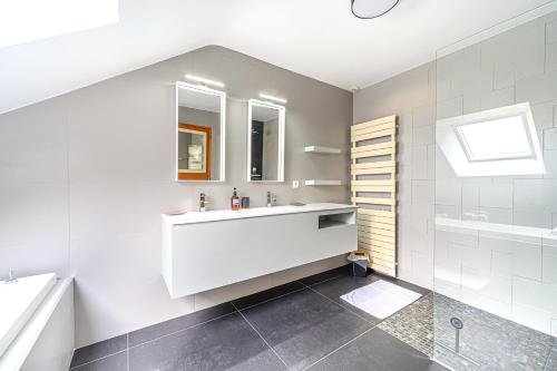 LE HAMEAU DE BIZOLE - Magnifique Maison contemporaine avec piscine chauffée في Saint-Nolff: حمام أبيض مع حوض وحوض استحمام