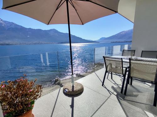 patio con ombrellone, tavolo e sedie di Holiday Home Gelsomino - GLA125 by Interhome a Gera Lario