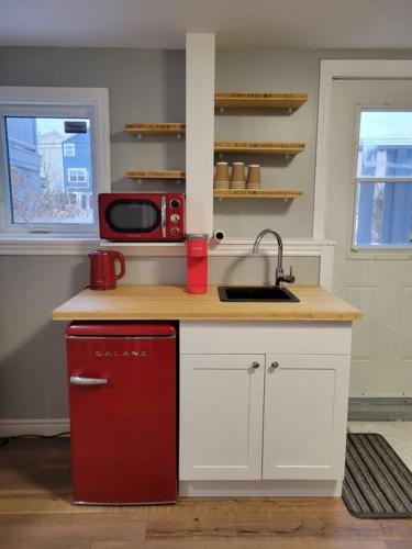 a kitchen with a red refrigerator and a microwave at Stylish one bedroom Apartment. 