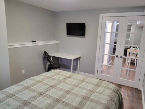 a bedroom with a bed and a desk and a window at Stylish one bedroom Apartment. 