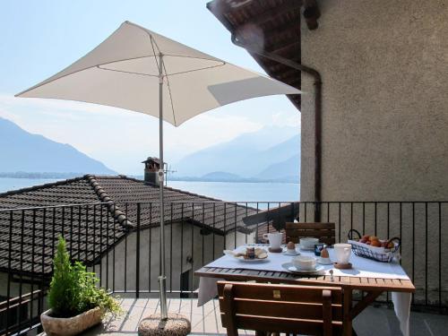 einen Tisch auf einem Balkon mit Sonnenschirm in der Unterkunft Apartment Titti - GLA133 by Interhome in Gera Lario