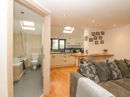a living room with a couch and a kitchen at Pump House in Horam