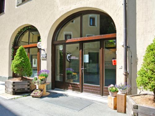 an entrance to a building with glass doors and potted plants at Apartment Residenza Chesa Margun 14-1 by Interhome in Surlej