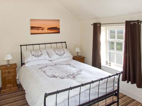 a bedroom with a large bed and a window at Curlew Cottage in Warslow