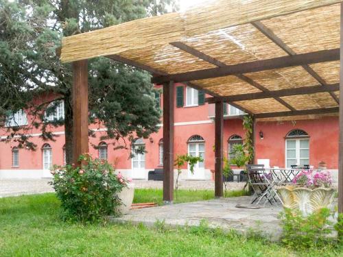 un pergolato in legno di fronte a un edificio rosso di Holiday Home La Mondianese - AST310 by Interhome a Montemagno