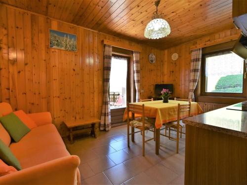 salon z drewnianymi ścianami, stołem i krzesłami w obiekcie Apartment Casa Crapena-1 by Interhome w Livigno