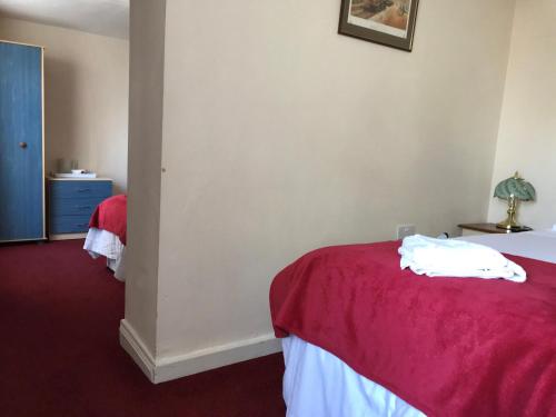 a bedroom with a bed with a red blanket at The Great Western B&B in Paignton