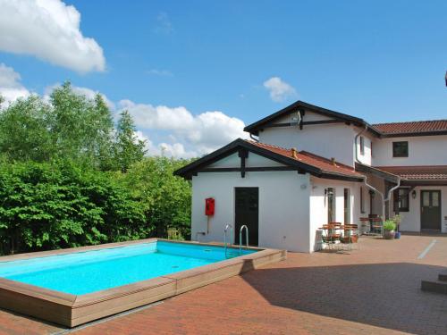 uma casa com piscina em frente a uma casa em Apartment Gästehaus Alte Schule-3 by Interhome em Dargun