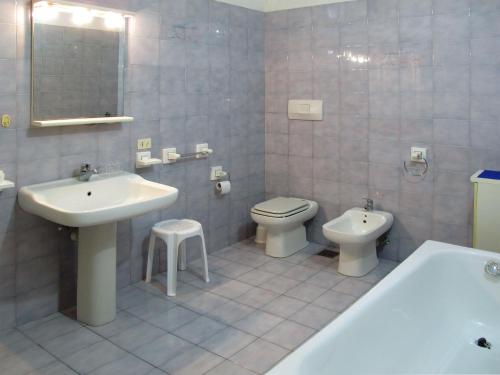 a bathroom with a sink and a toilet and a tub at Apartment Angeli by Interhome in Vignola