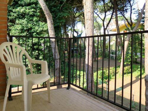 una sedia bianca seduta su un portico con recinzione di Casa Sandra a Rosolina Mare