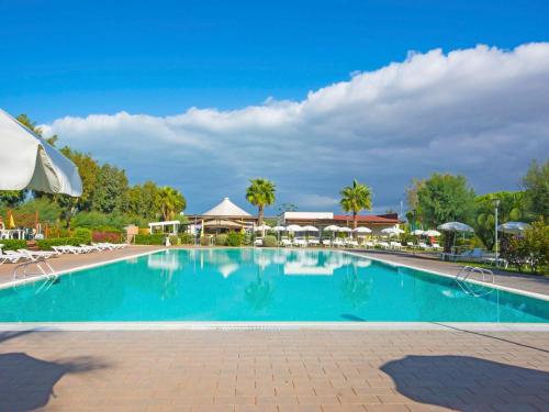 einen Pool in einem Resort mit Stühlen und Bäumen in der Unterkunft Holiday Home Cecina Mare-3 by Interhome in Marina di Cecina
