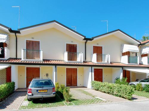 ein Haus mit einem davor geparkt in der Unterkunft Holiday Home Mediterraneo-2 by Interhome in Rosolina Mare