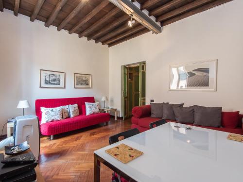 ローマにあるApartment Piazza Navona Charming by Interhomeのリビングルーム(赤いソファ、テーブル付)