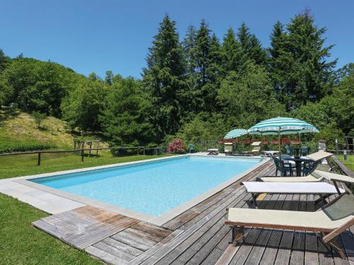 einen Pool mit 2 Stühlen und einem Sonnenschirm in der Unterkunft Apartment Le Bore-2 by Interhome in Sassi