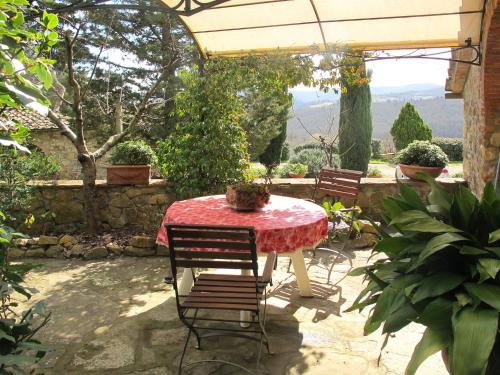 a table with a red table cloth on a patio at Holiday Home Vignole by Interhome in Panzano