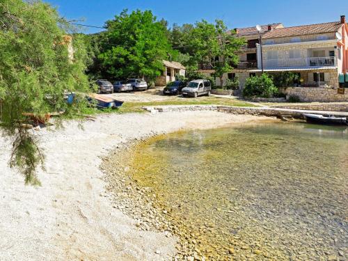 a beach with cars parked in front of a building at Apartment Šarenko-5 by Interhome in Vela Luka