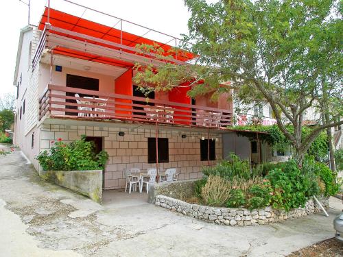 a building with a balcony with tables and chairs at Apartment Šarenko-2 by Interhome in Vela Luka