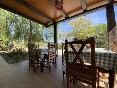 un porche cubierto con mesa y sillas en LAS PALMERAS en Pizarra