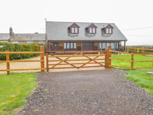 a wooden fence in front of a house at The Donkey Shed in Sherborne