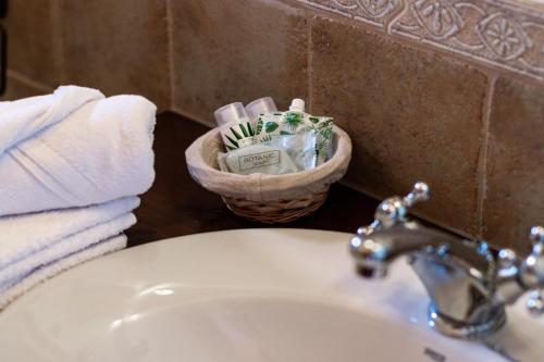 a bathroom sink with a basket of towels and a toothbrush at Hotel Rural La Sal in Salinas de Hoz