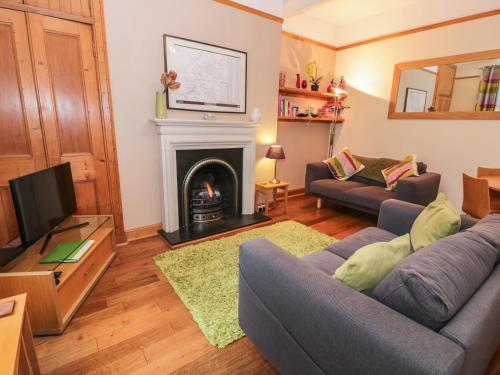 a living room with a couch and a fireplace at 63 Rosetta Road in Peebles