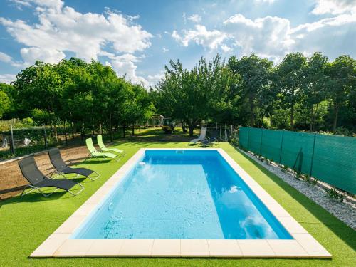 a swimming pool in a yard with chairs and a fence at Holiday Home Zsuzsi by Interhome in Balatonszemes