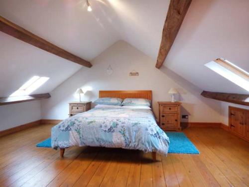 Schlafzimmer mit einem Bett und Holzboden in der Unterkunft Garreg Wen Isaf Bach in Pen-y-groes