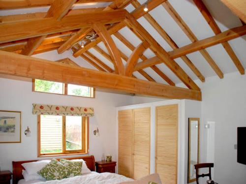 a bedroom with a bed and a ceiling with wooden beams at The Springs in Ryde