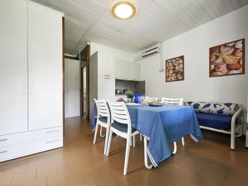 ein Esszimmer mit einem blauen Tisch und Stühlen in der Unterkunft Holiday Home Bungalow in legno by Interhome in Baia Domizia