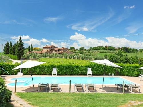 a swimming pool with chairs and umbrellas at Apartment Villastrada-2 by Interhome in Villastrada