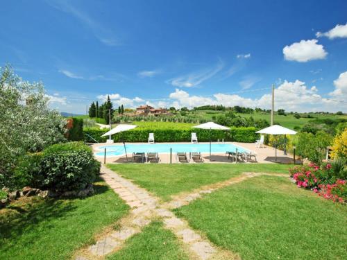 a pool in a yard with chairs and umbrellas at Apartment Villastrada-2 by Interhome in Villastrada